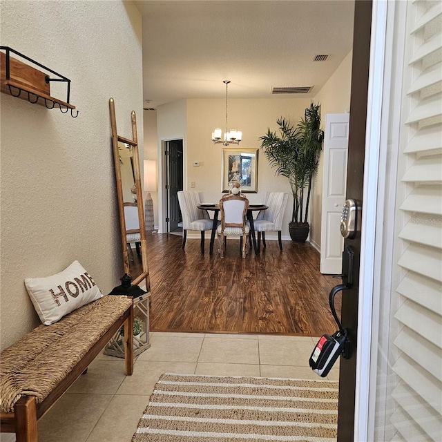 interior space featuring a chandelier, visible vents, and tile patterned floors