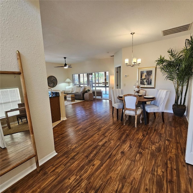 dining space with baseboards, visible vents, dark wood-type flooring, and ceiling fan with notable chandelier