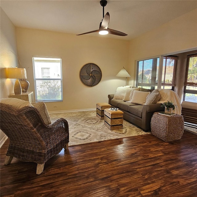 living room with ceiling fan, baseboards, and wood finished floors