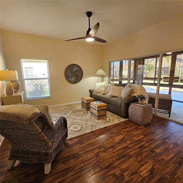 living area featuring baseboards, a ceiling fan, and wood finished floors