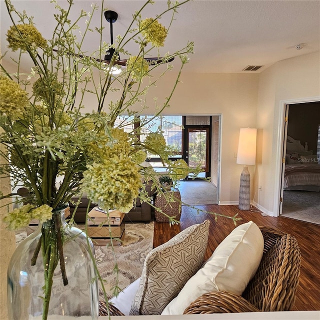 living area with a textured ceiling, baseboards, and wood finished floors