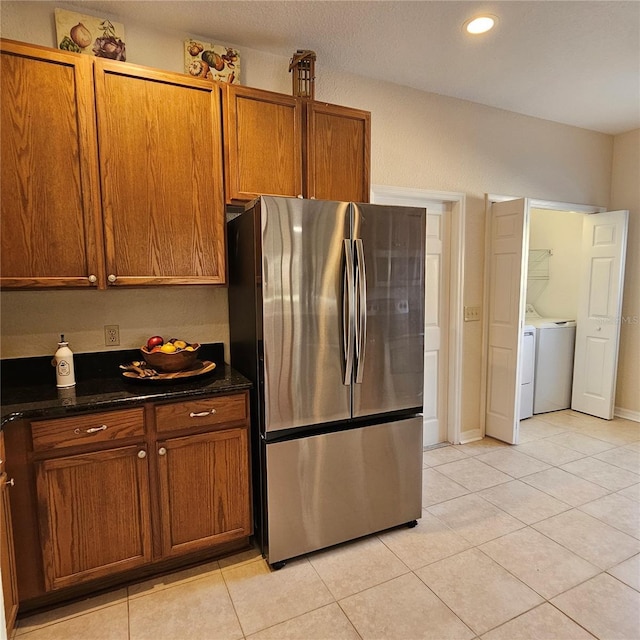 kitchen featuring light tile patterned floors, recessed lighting, freestanding refrigerator, and brown cabinets