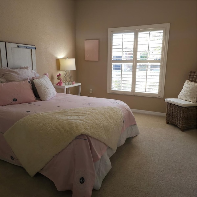 bedroom with baseboards and light colored carpet