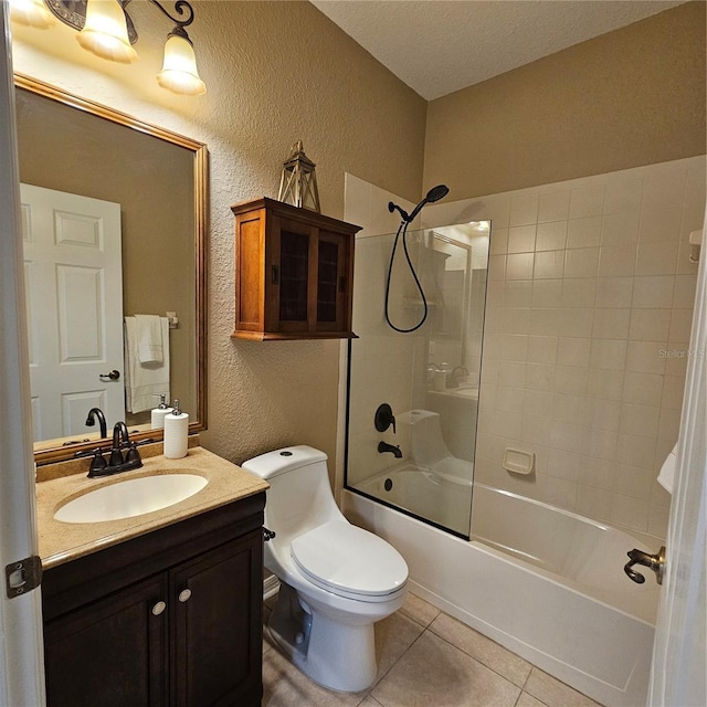 bathroom featuring a textured wall, toilet, shower / tub combination, tile patterned floors, and vanity