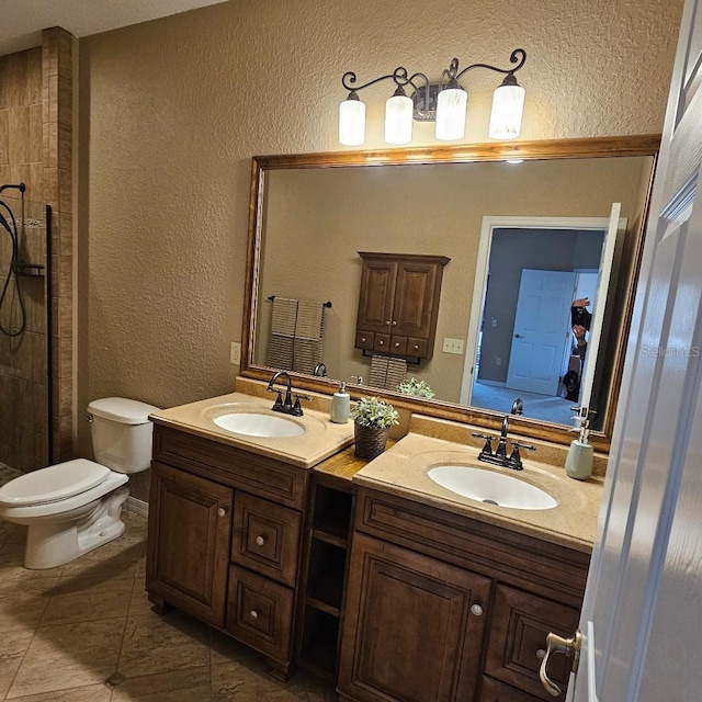 full bathroom with double vanity, a sink, and a textured wall