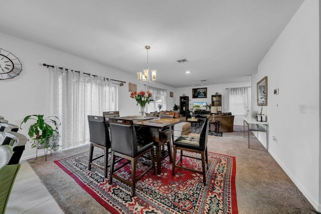 dining room featuring a wealth of natural light, light tile patterned floors, and an inviting chandelier