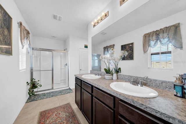 bathroom featuring a shower with door, tile patterned flooring, and vanity