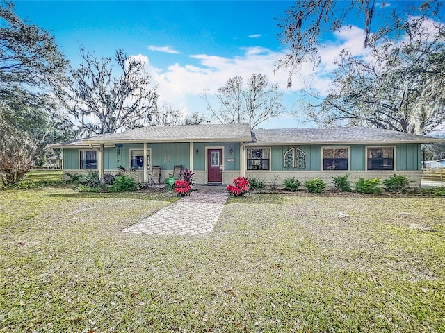 ranch-style house with covered porch and a front lawn