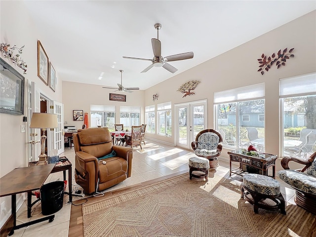 tiled living room with a towering ceiling, a wealth of natural light, and french doors