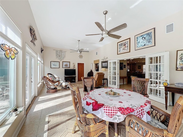 dining space featuring a high ceiling, light tile patterned floors, ceiling fan, and french doors