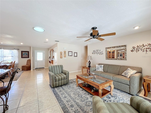 tiled living room featuring ceiling fan and a textured ceiling