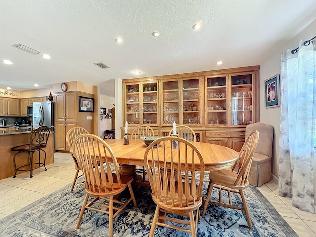 tiled dining room featuring a textured ceiling