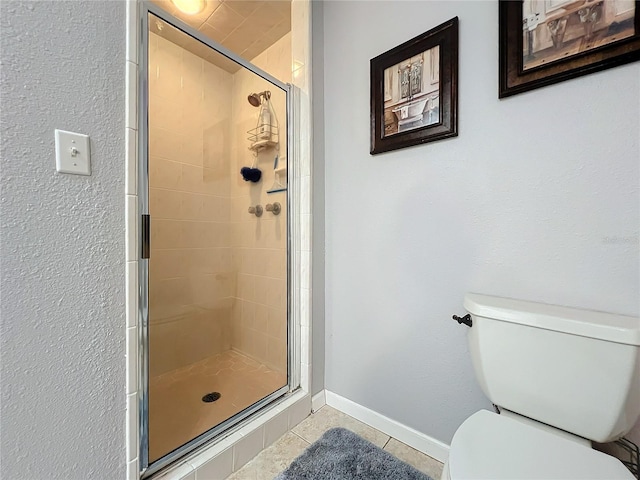 bathroom with a shower with door, tile patterned floors, and toilet