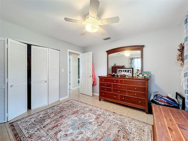 tiled bedroom featuring ceiling fan and a closet