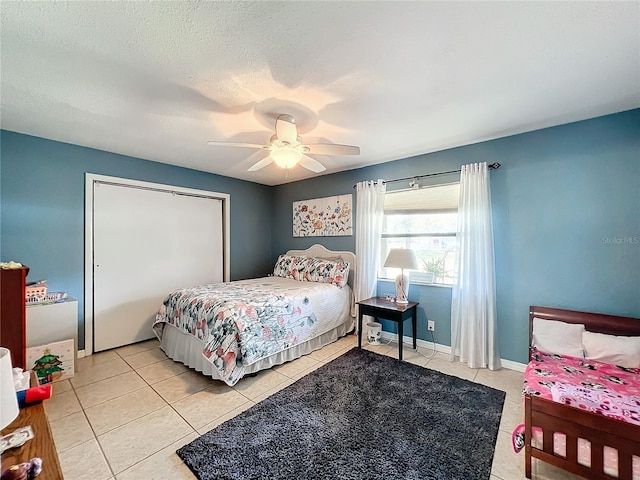 tiled bedroom with ceiling fan and a textured ceiling