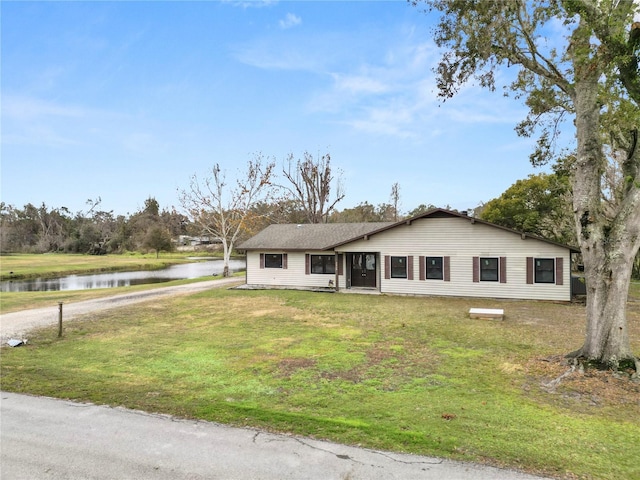 ranch-style house with a water view and a front lawn