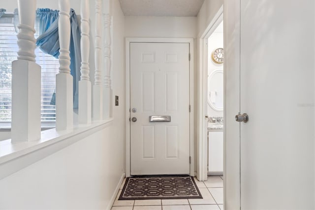 doorway to outside with light tile patterned flooring