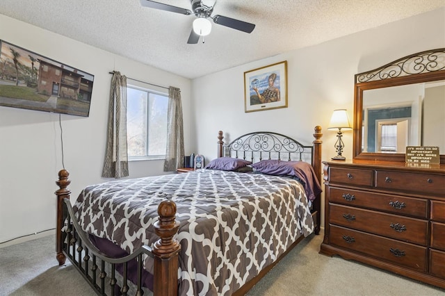 carpeted bedroom featuring a textured ceiling and ceiling fan