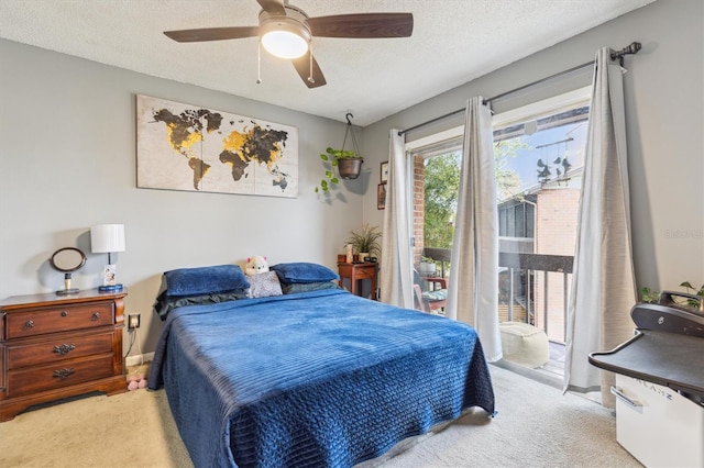 carpeted bedroom with ceiling fan, access to exterior, and a textured ceiling