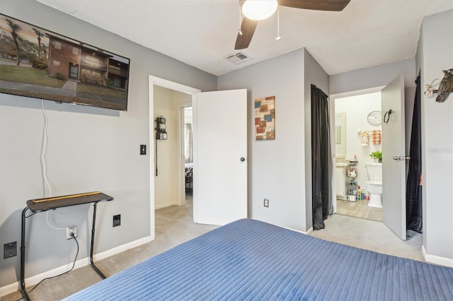 bedroom featuring connected bathroom, a textured ceiling, light colored carpet, and ceiling fan