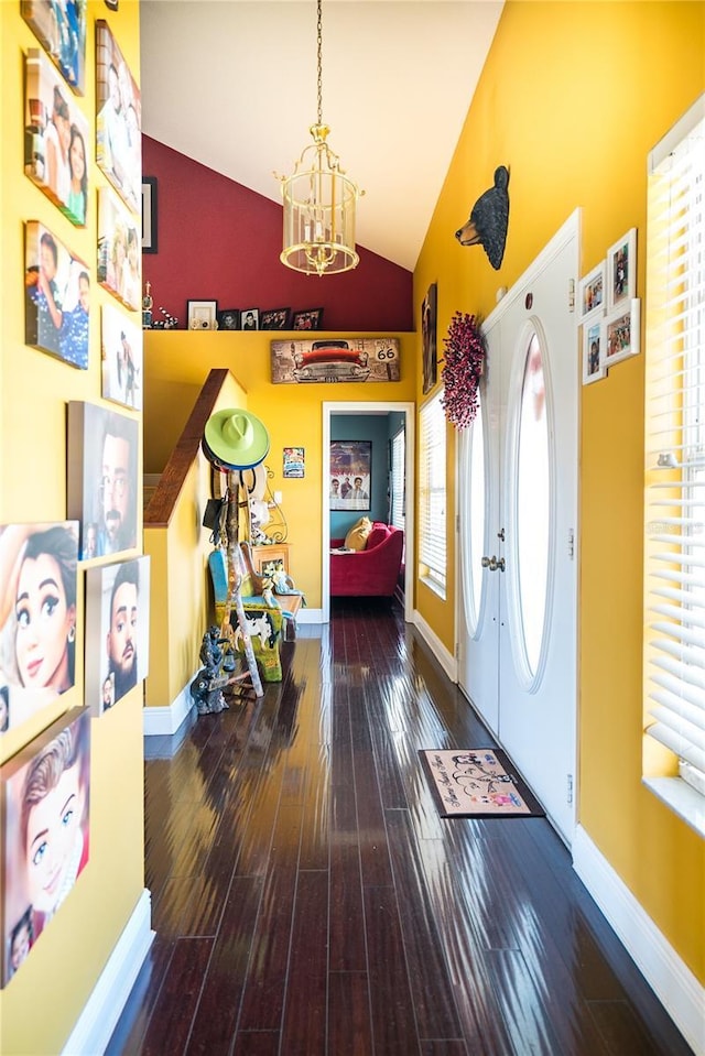 entrance foyer featuring wood-type flooring, a chandelier, and high vaulted ceiling