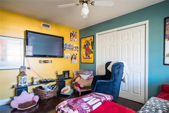 bedroom with ceiling fan, dark wood-type flooring, and a closet