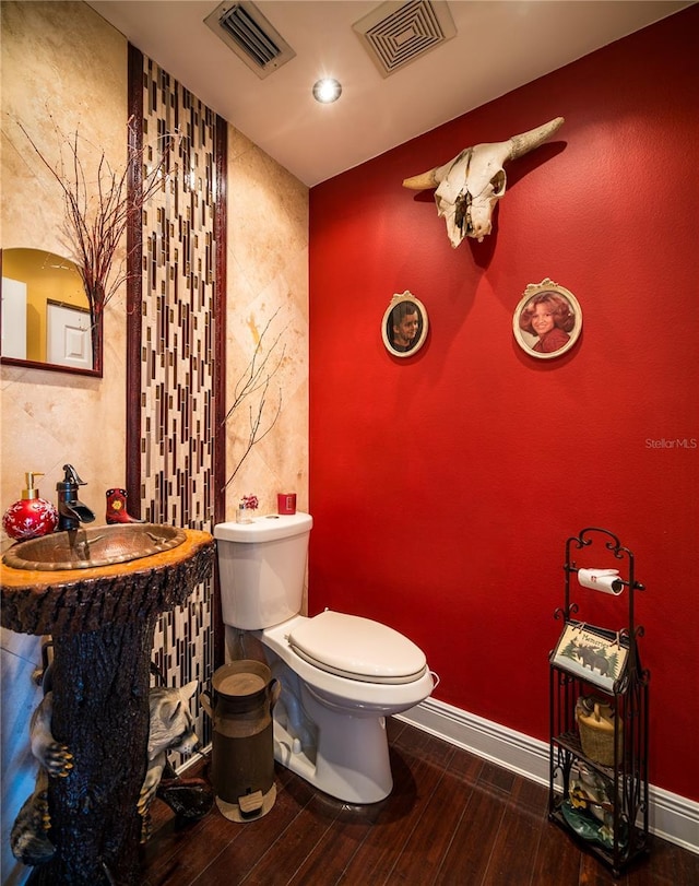 bathroom featuring toilet and wood-type flooring