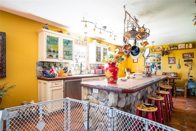 kitchen with a kitchen breakfast bar, white cabinets, and sink