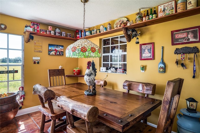 tiled dining space featuring a textured ceiling