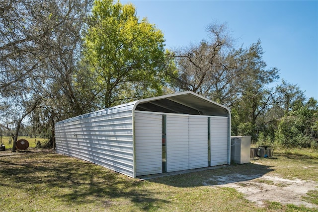 view of outdoor structure featuring a carport and a lawn