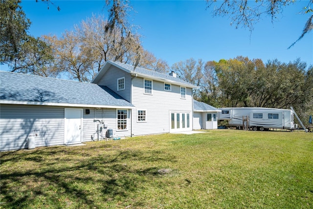 back of property with french doors and a lawn