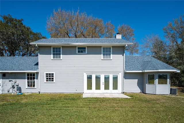 back of house with french doors, a lawn, and central AC