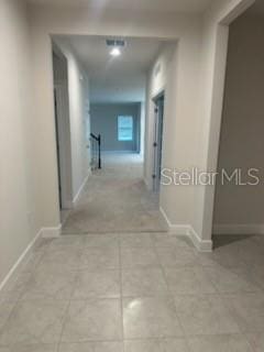 hall with light tile patterned floors