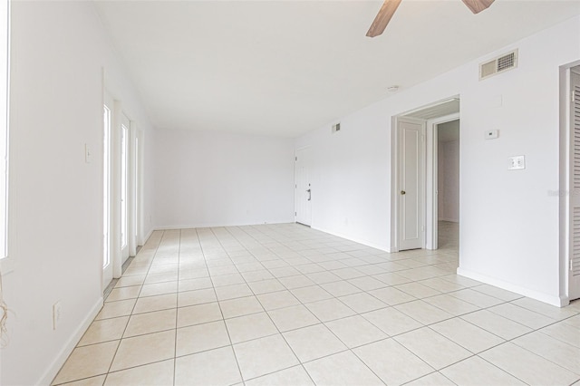 tiled spare room featuring plenty of natural light and ceiling fan