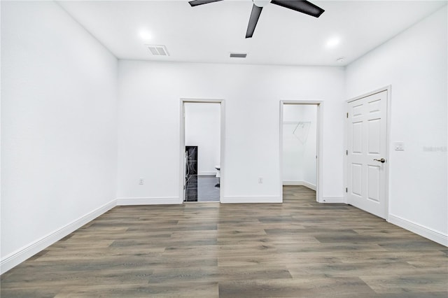 unfurnished bedroom with dark hardwood / wood-style flooring, a spacious closet, and ceiling fan