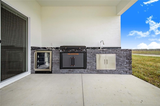 view of patio with a grill, area for grilling, and sink