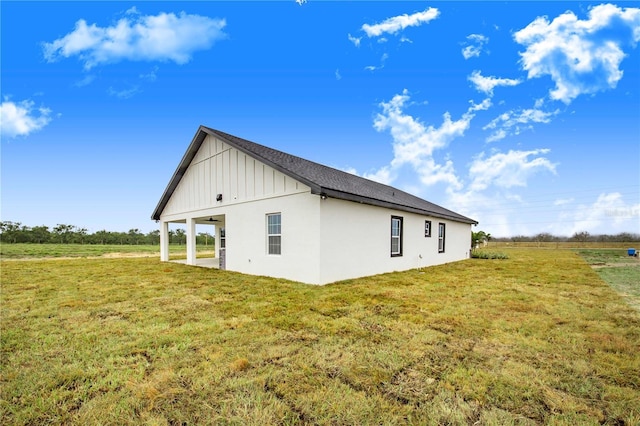 view of property exterior with a yard and a rural view