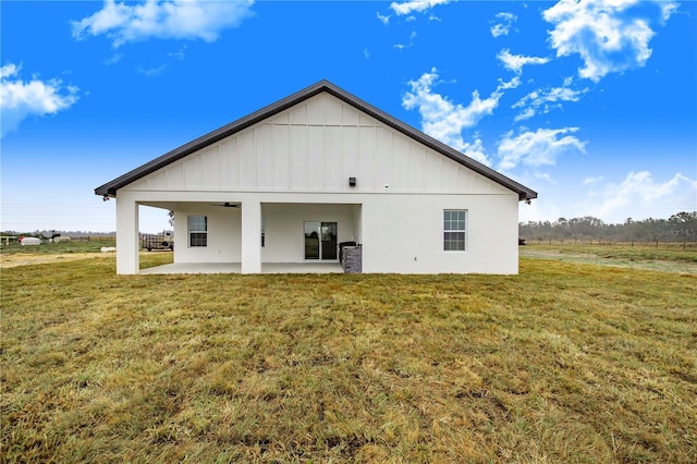 back of property featuring ceiling fan, a yard, and a patio