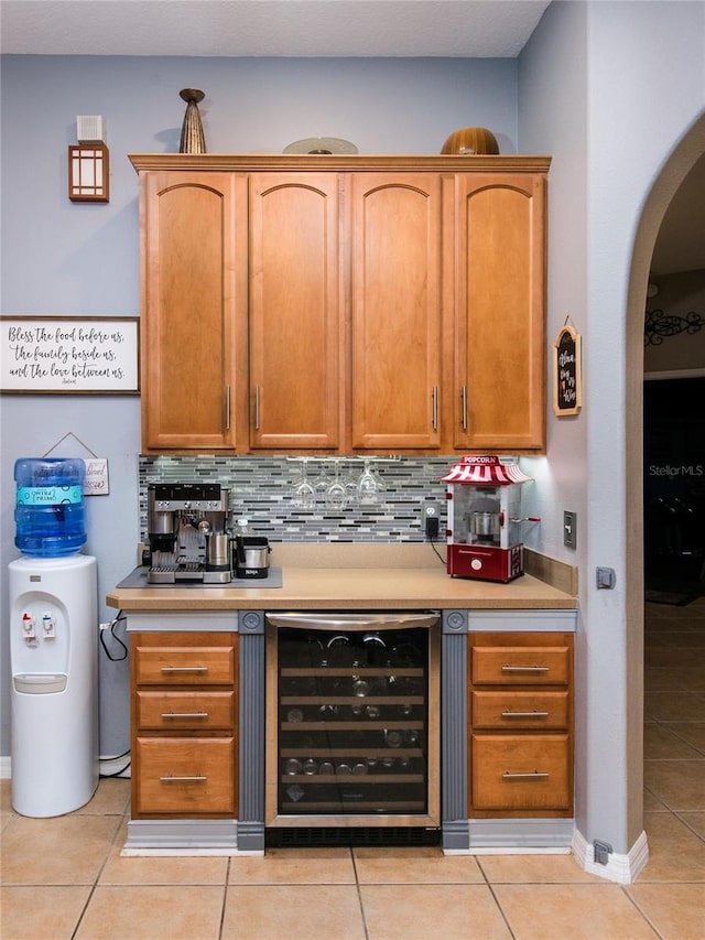 bar featuring wine cooler, light tile patterned floors, and backsplash