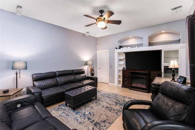 living room with light tile patterned floors, built in shelves, and ceiling fan