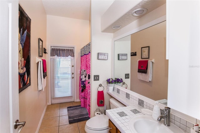 bathroom with tile patterned floors, toilet, decorative backsplash, and vanity