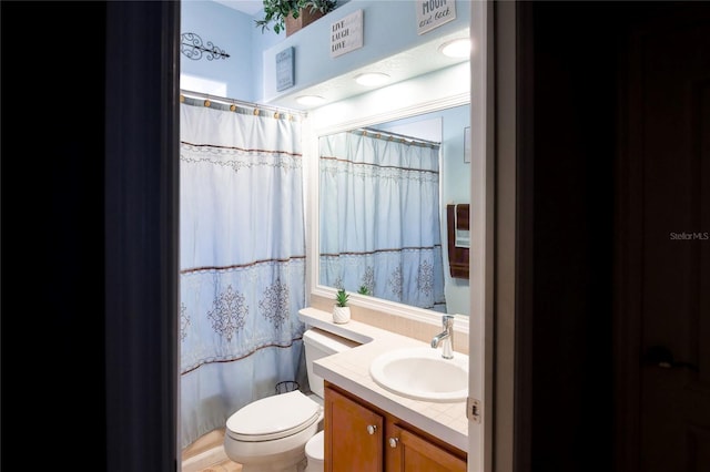 bathroom with walk in shower, vanity, and toilet