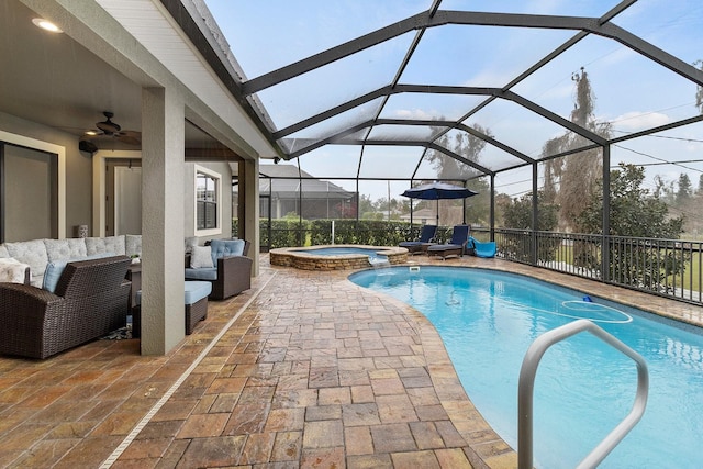 view of pool with outdoor lounge area, an in ground hot tub, ceiling fan, glass enclosure, and a patio area