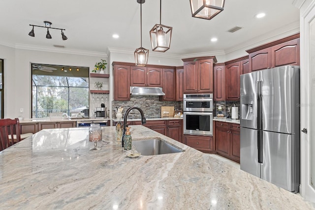 kitchen with sink, decorative light fixtures, ornamental molding, appliances with stainless steel finishes, and light stone countertops