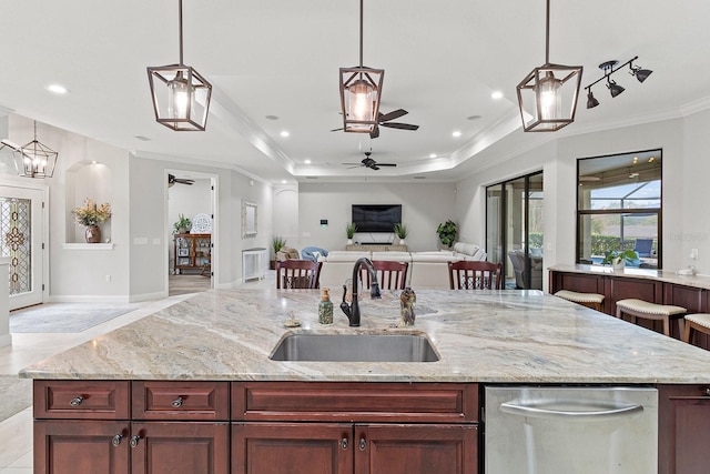 kitchen with sink, ornamental molding, light stone countertops, and a raised ceiling