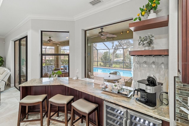 bar featuring ornamental molding, wine cooler, and light stone counters