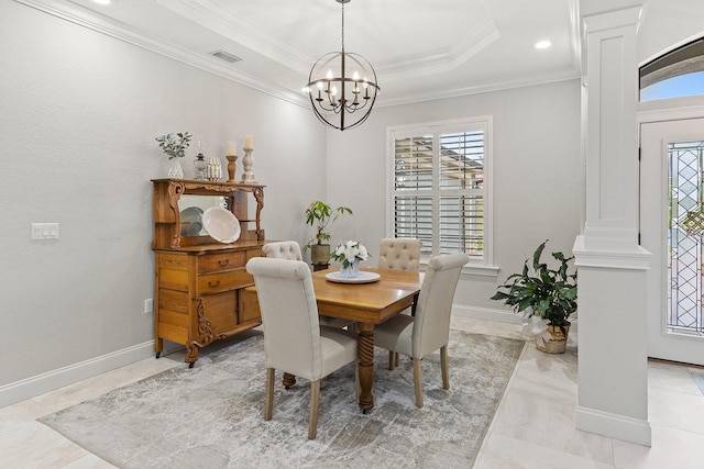 dining space featuring a raised ceiling, ornamental molding, plenty of natural light, and ornate columns