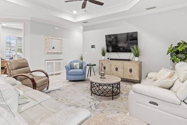 living room featuring a raised ceiling, ornamental molding, and ceiling fan