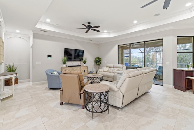 living room with crown molding, a tray ceiling, and ceiling fan