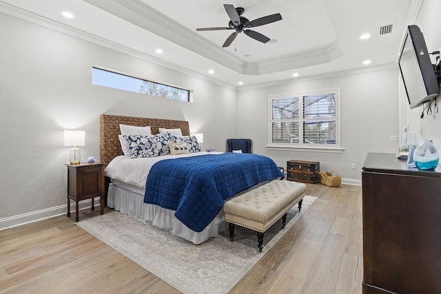 bedroom with crown molding, light hardwood / wood-style flooring, a raised ceiling, and ceiling fan